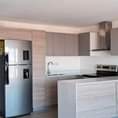 Puede ser una imagen de isla de cocina, campana extractora, iluminación, en interiores y puerta corrediza